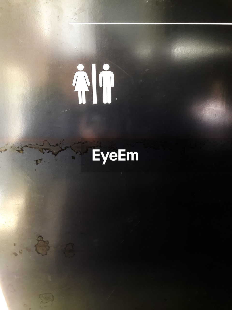 Restroom sign on metallic wall