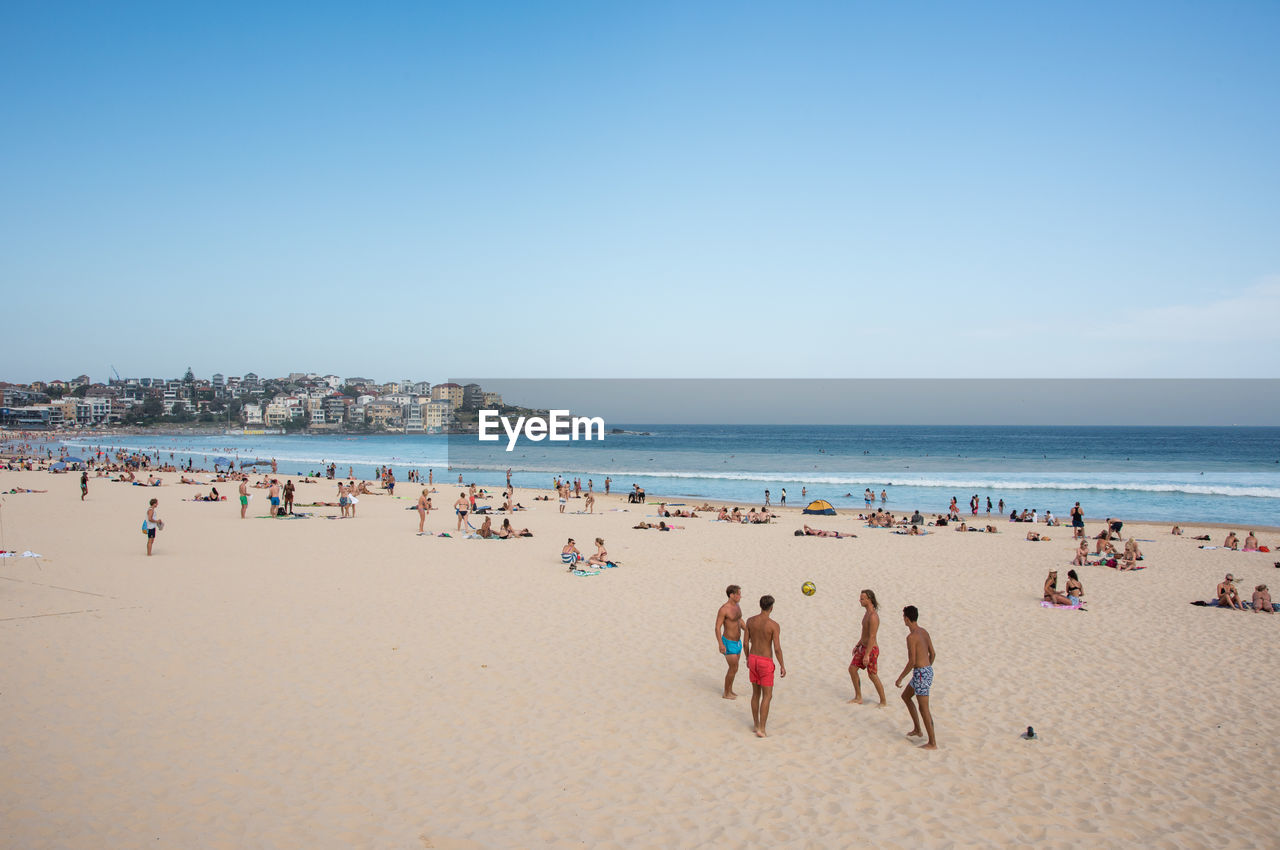 Crowd at beach against sky