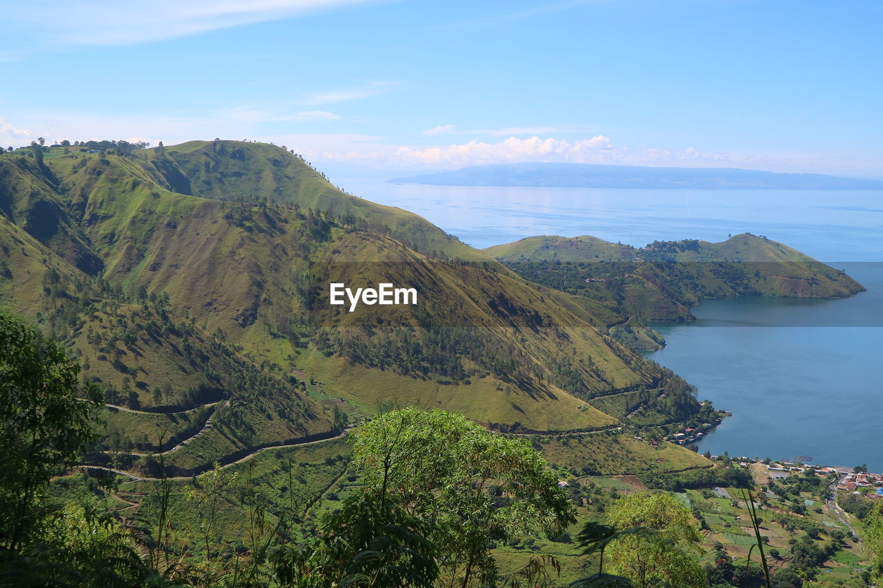 Scenic view of sea and mountains against sky