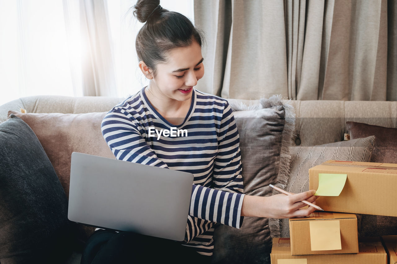 side view of young man using digital tablet while sitting on sofa at home