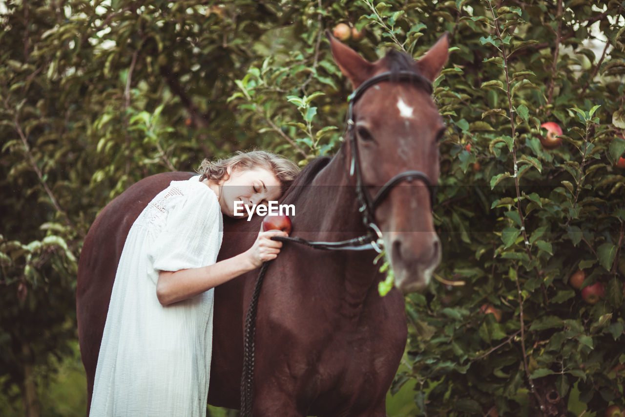 Woman leaning on horse in farm