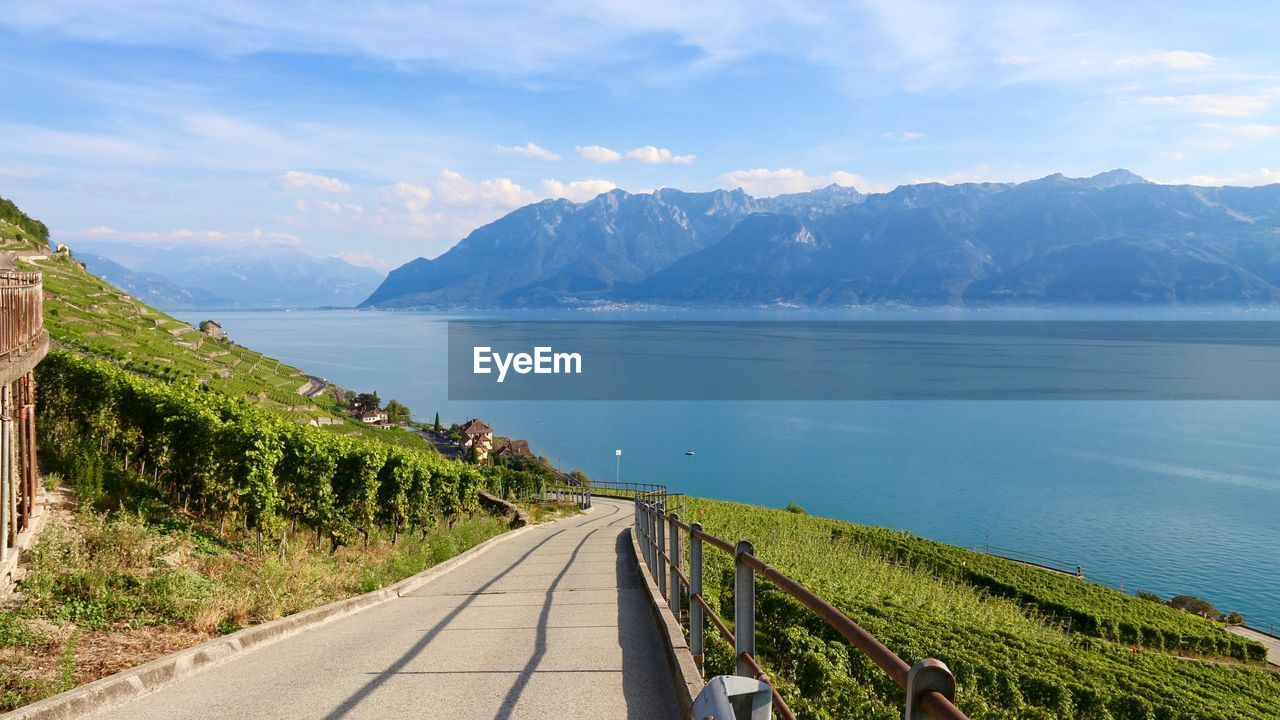 Scenic view of road by sea against sky