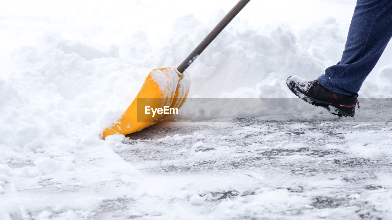 Man shoveling snow off of driveway in heavy snow storm 