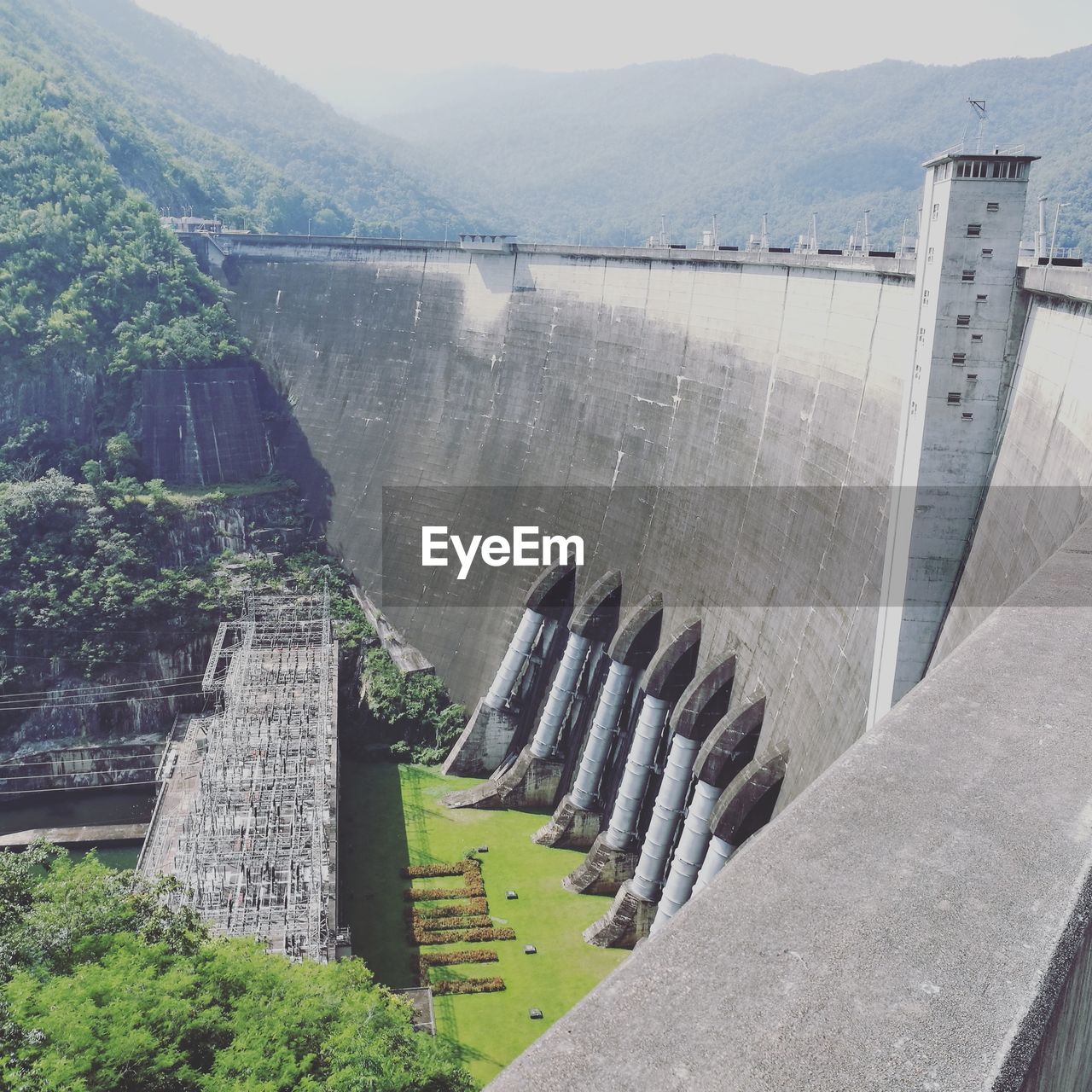 HIGH ANGLE VIEW OF DAM AGAINST MOUNTAINS