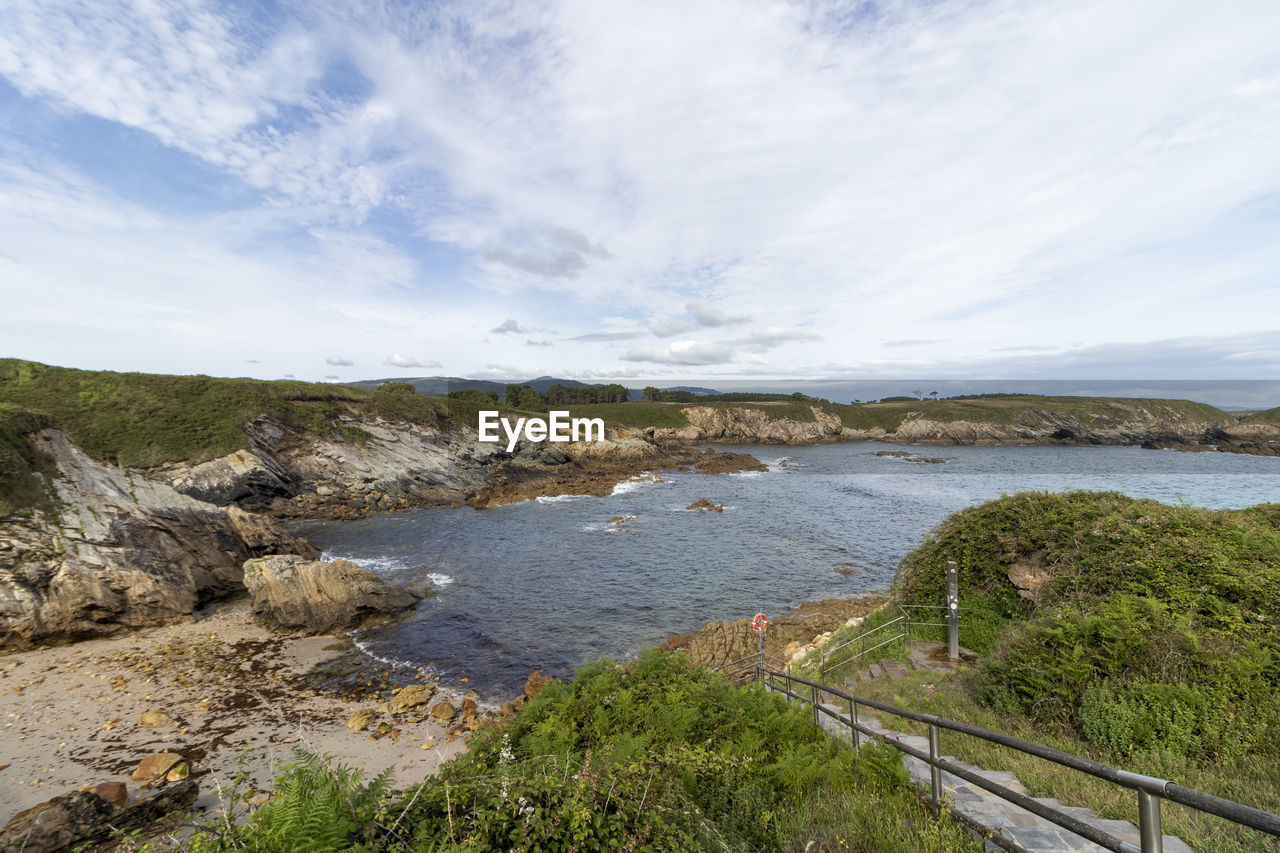 water, coast, shore, sky, sea, body of water, scenics - nature, nature, land, cloud, beauty in nature, landscape, environment, cliff, beach, plant, no people, reservoir, tranquility, mountain, ocean, travel, tranquil scene, travel destinations, bay, day, rock, terrain, cove, outdoors, non-urban scene, coastline, tourism, grass