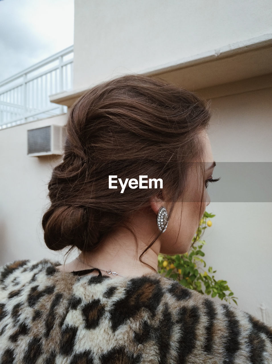 Rear view of woman looking away against wall