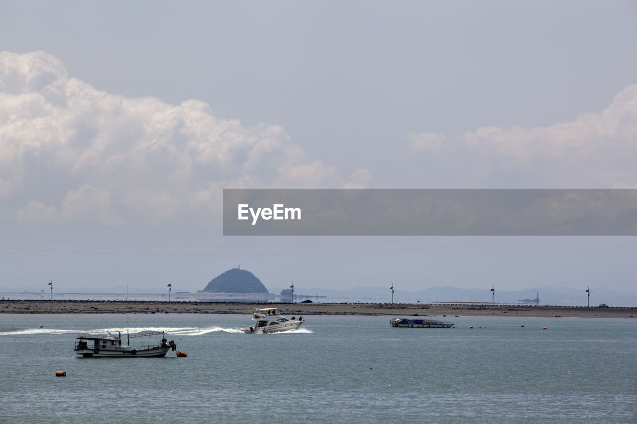 Boats on sea by daebudo island against sky