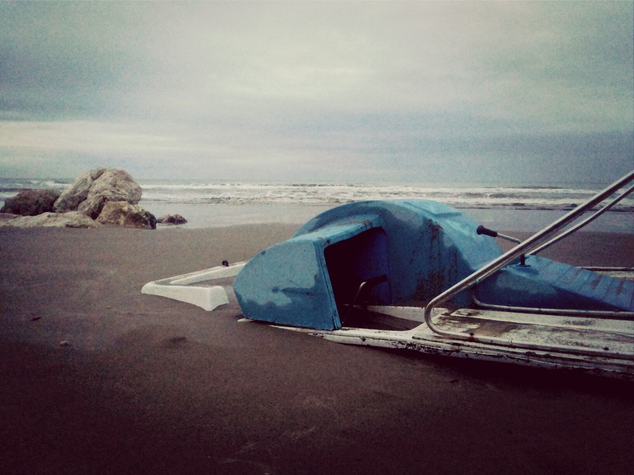 Abandoned boat on beach against sky