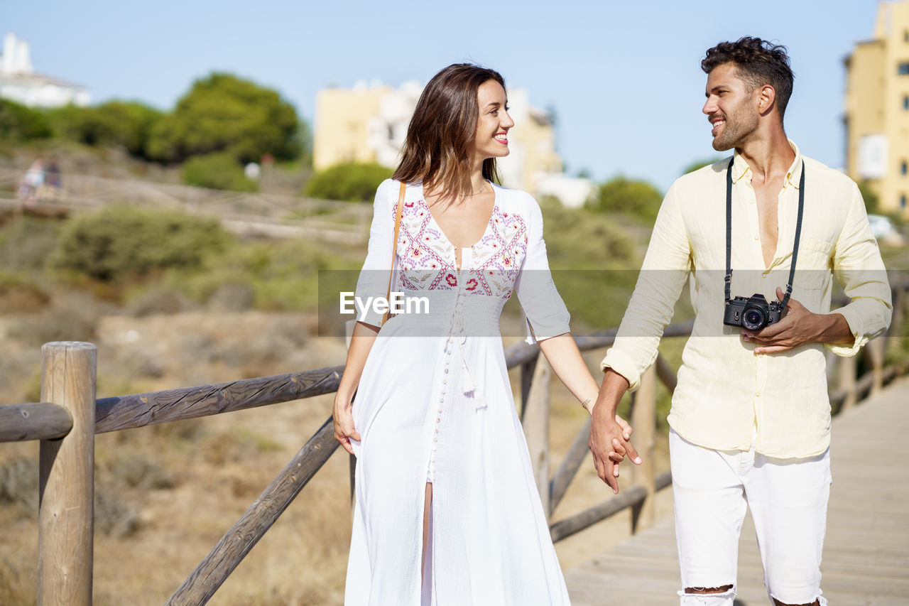 Couple holding hands while standing outdoors