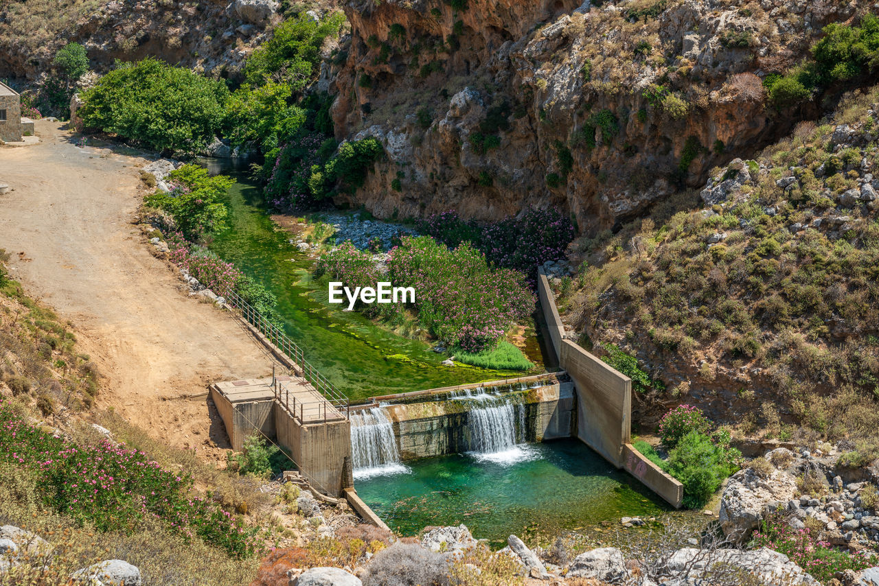 water, nature, high angle view, rock, scenics - nature, beauty in nature, no people, environment, day, plant, reservoir, river, dam, architecture, waterfall, tranquility, hydroelectric power, built structure, land, outdoors, mountain, tree, non-urban scene, wadi, tranquil scene, sunlight, valley, environmental conservation, travel destinations, landscape, rock formation, water feature, cliff, travel