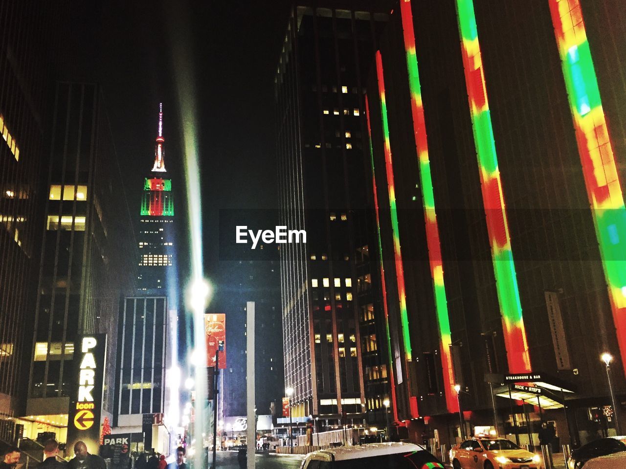 Illuminated empire state building against sky in city at night