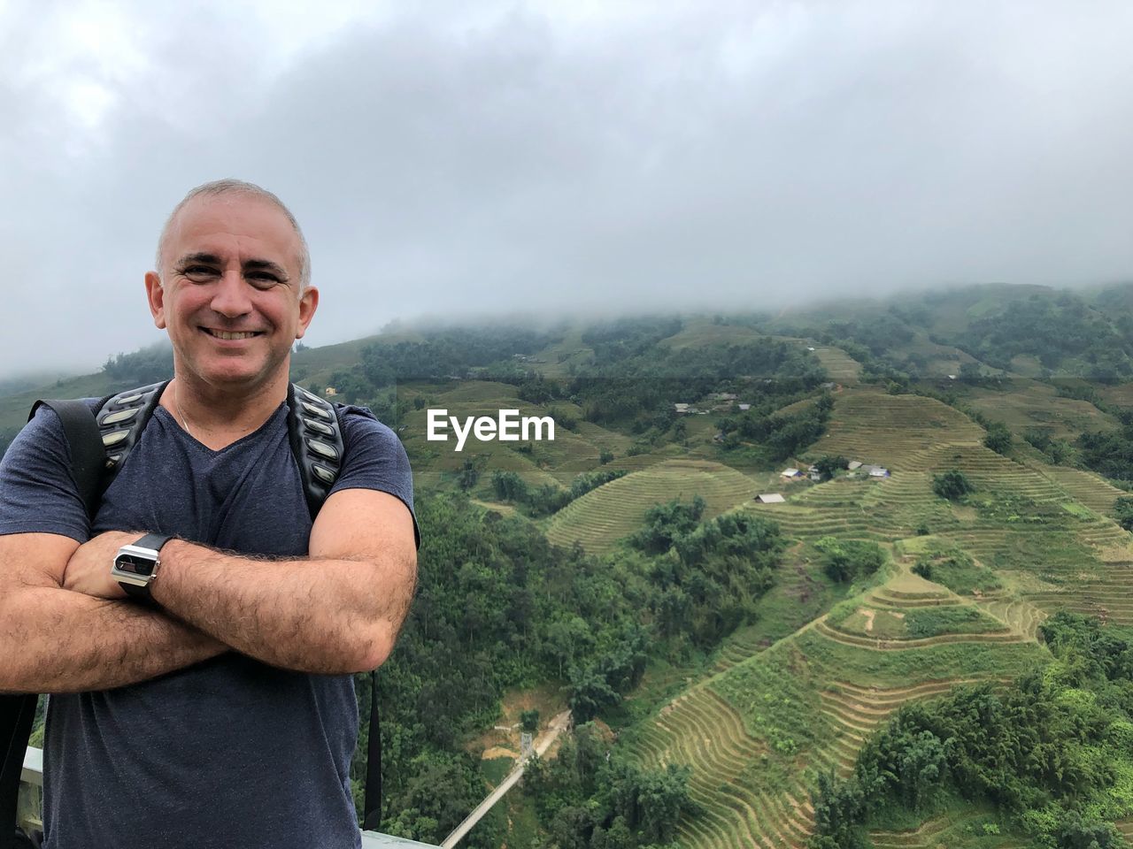 Portrait of smiling man standing on landscape against sky