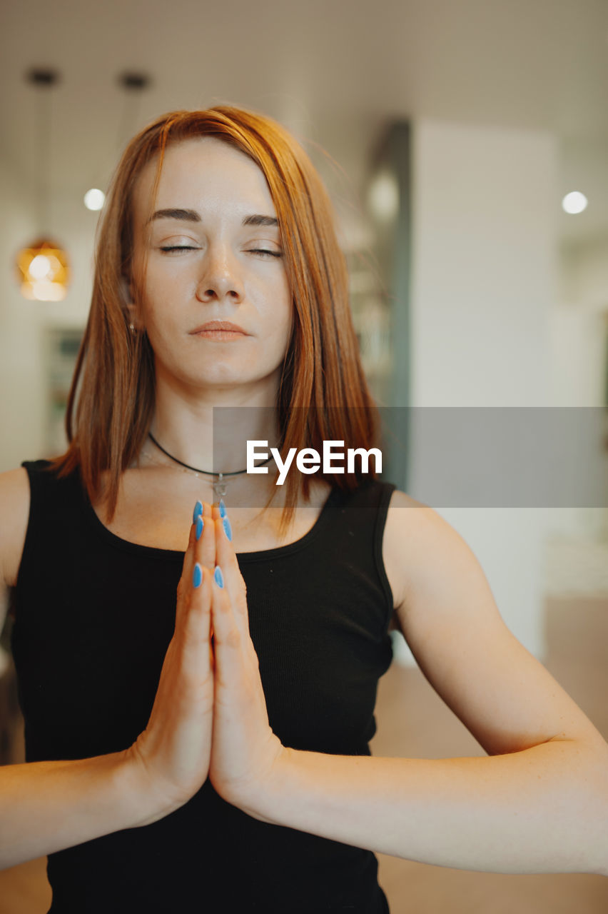 one person, women, adult, indoors, young adult, yoga, portrait, lifestyles, hairstyle, long hair, exercising, front view, meditating, wellbeing, female, human hair, relaxation, physical fitness, zen-like, redhead, waist up, clothing, spirituality, sitting, focus on foreground, contemplation, blond hair, standing, brown hair