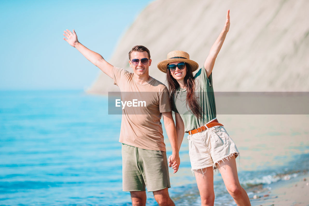 FULL LENGTH OF YOUNG WOMAN AGAINST SEA