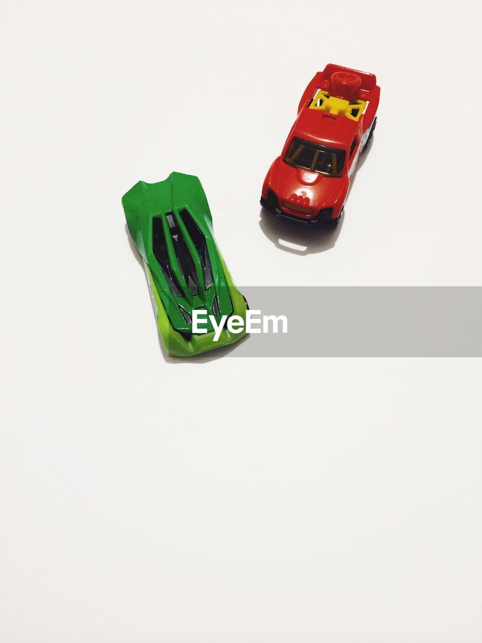 Red and green toy cars against white background
