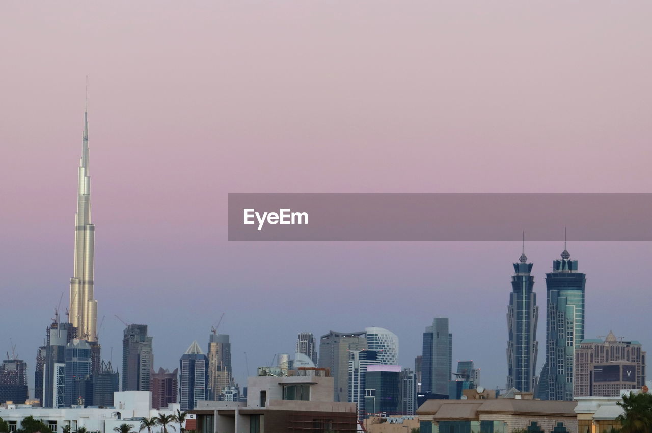 MODERN BUILDINGS IN CITY AT SUNSET