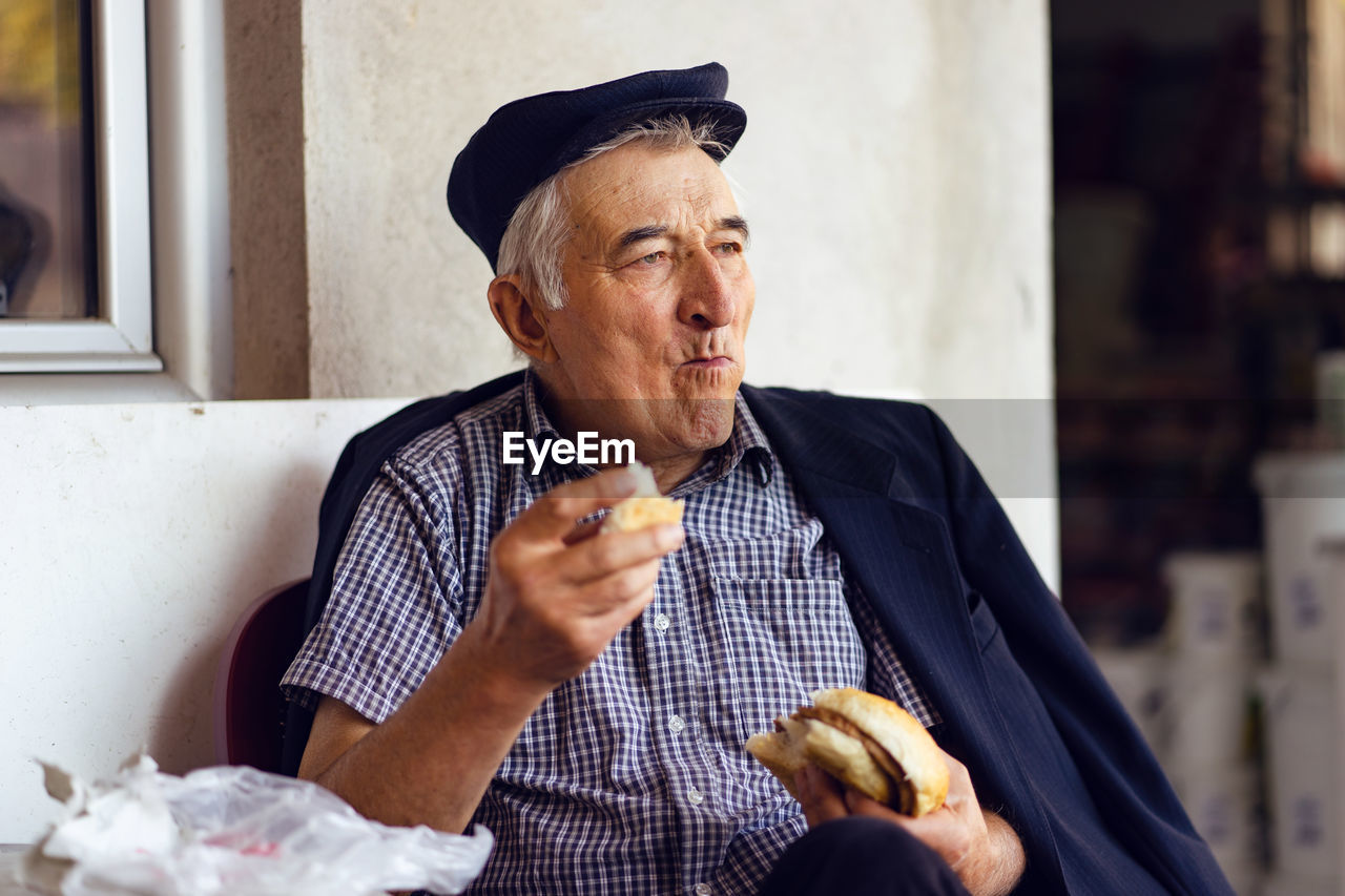 Man eating bread while sitting at home