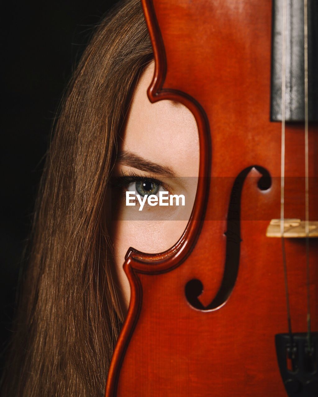 Close-up portrait of a young woman with violin