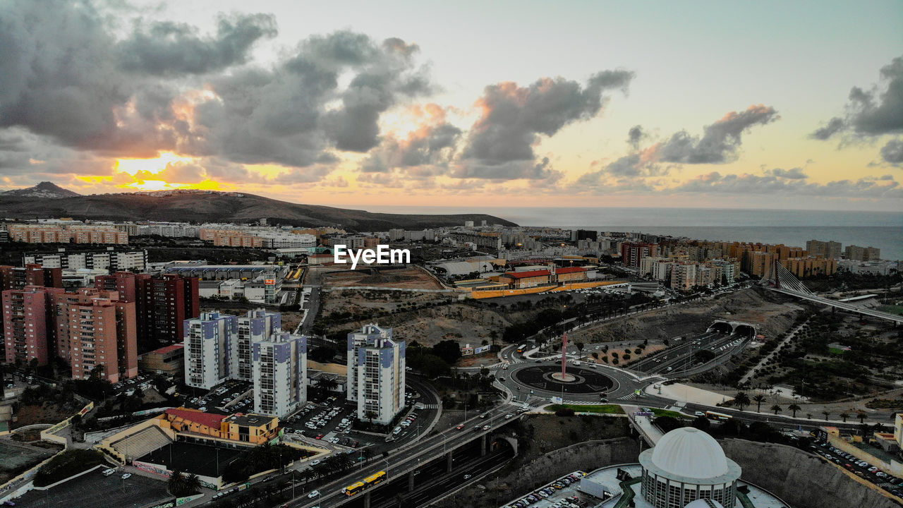 HIGH ANGLE VIEW OF BUILDINGS BY SEA AGAINST SKY