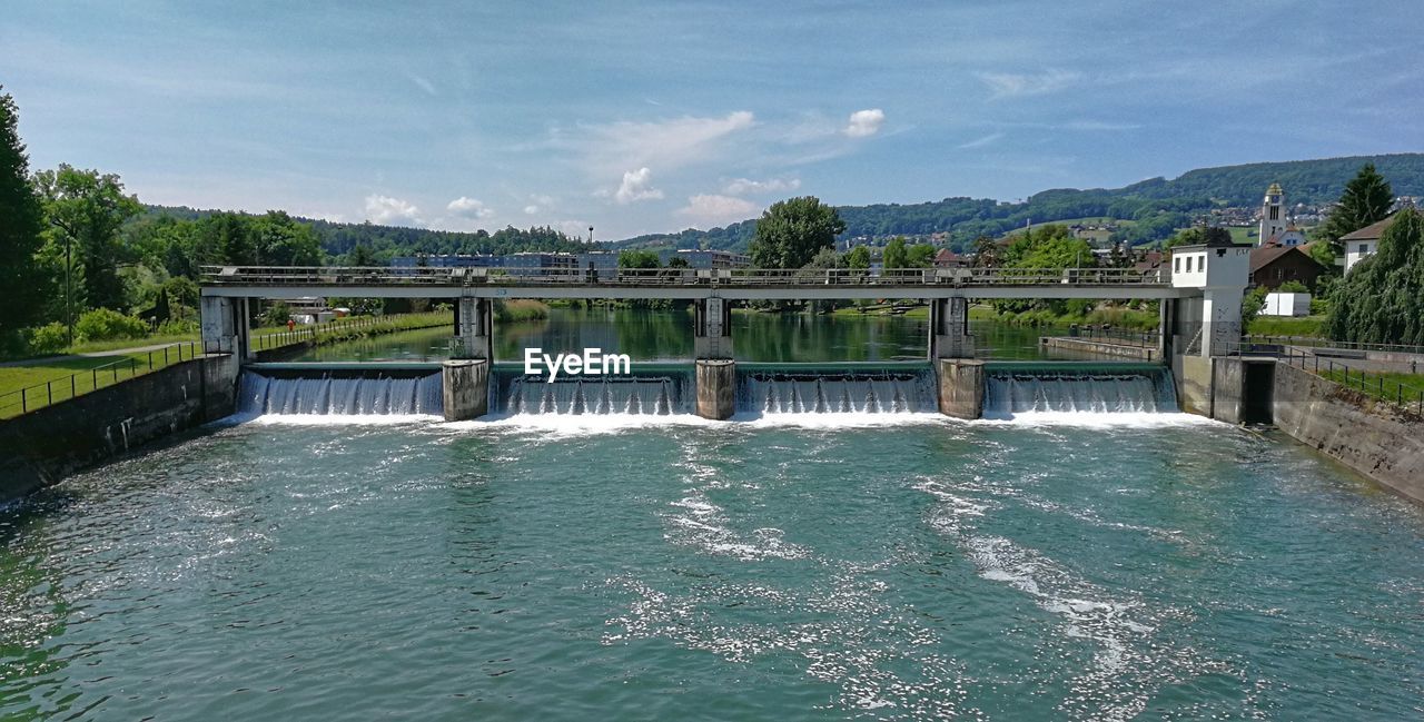 VIEW OF DAM ON BRIDGE AGAINST SKY