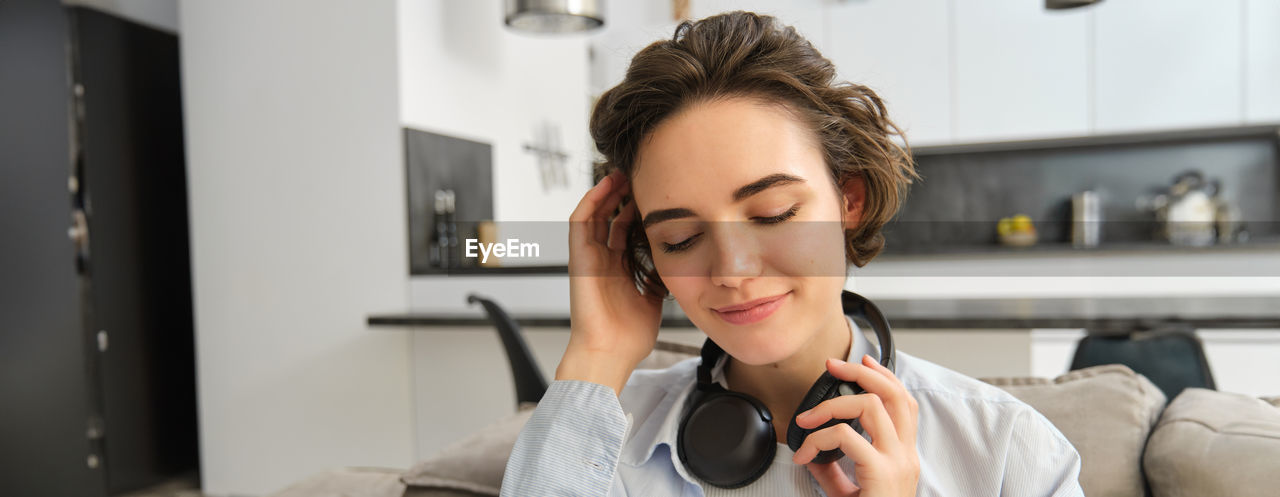 close-up of young woman using mobile phone at home