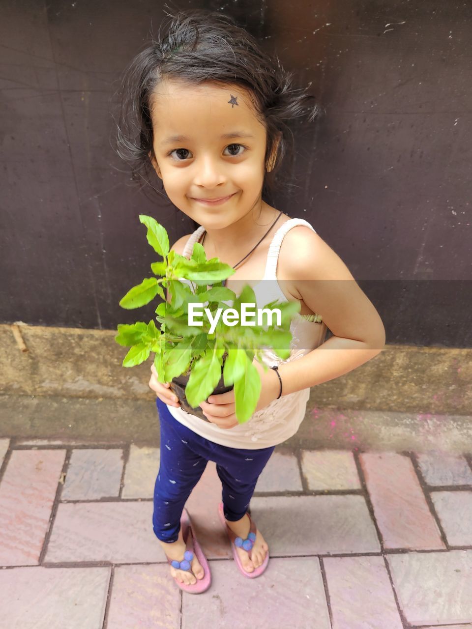 Portrait of young firl holding plant