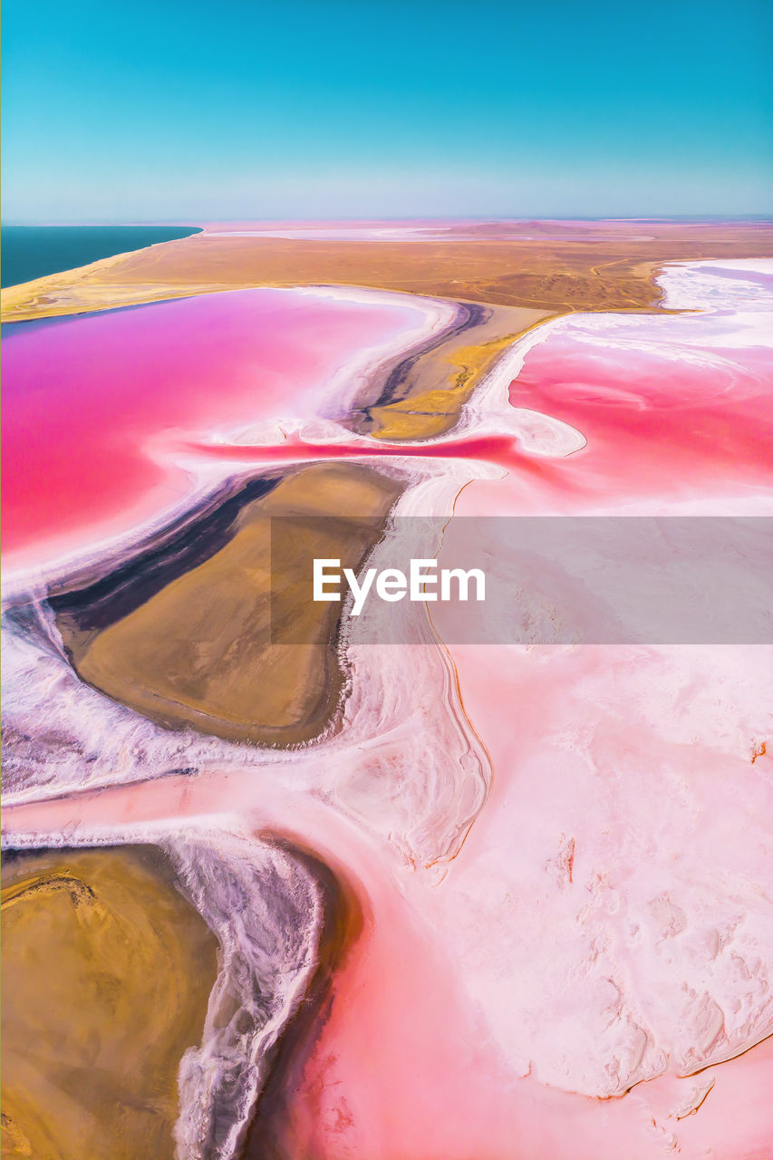 Aerial view of a partially dried up salt lake divided by an oblique sunny day. natural extraction 