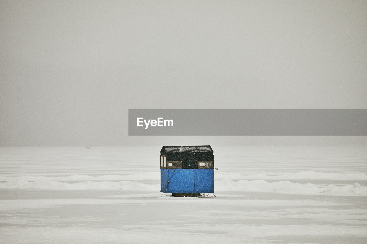 Ice fishing shanty on frozen lake in snow storm