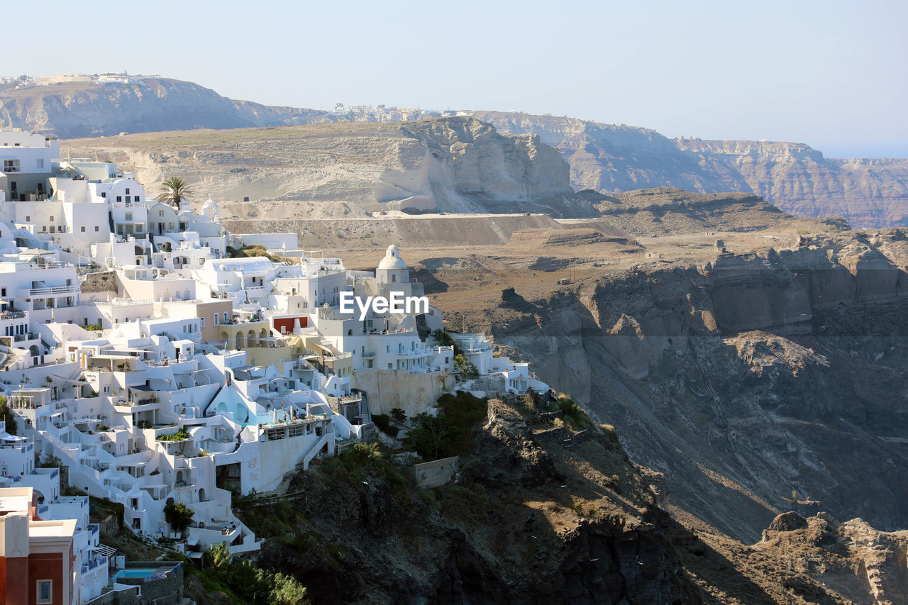 Aerial view of townscape and mountains against clear sky