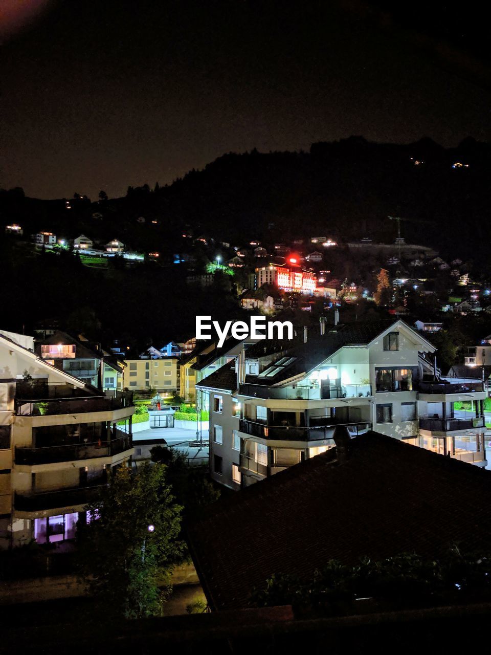 HIGH ANGLE VIEW OF ILLUMINATED BUILDINGS IN CITY