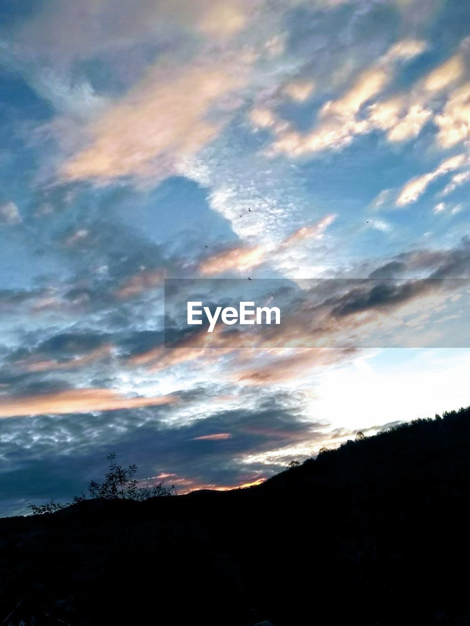 LOW ANGLE VIEW OF DRAMATIC SKY OVER SILHOUETTE MOUNTAIN