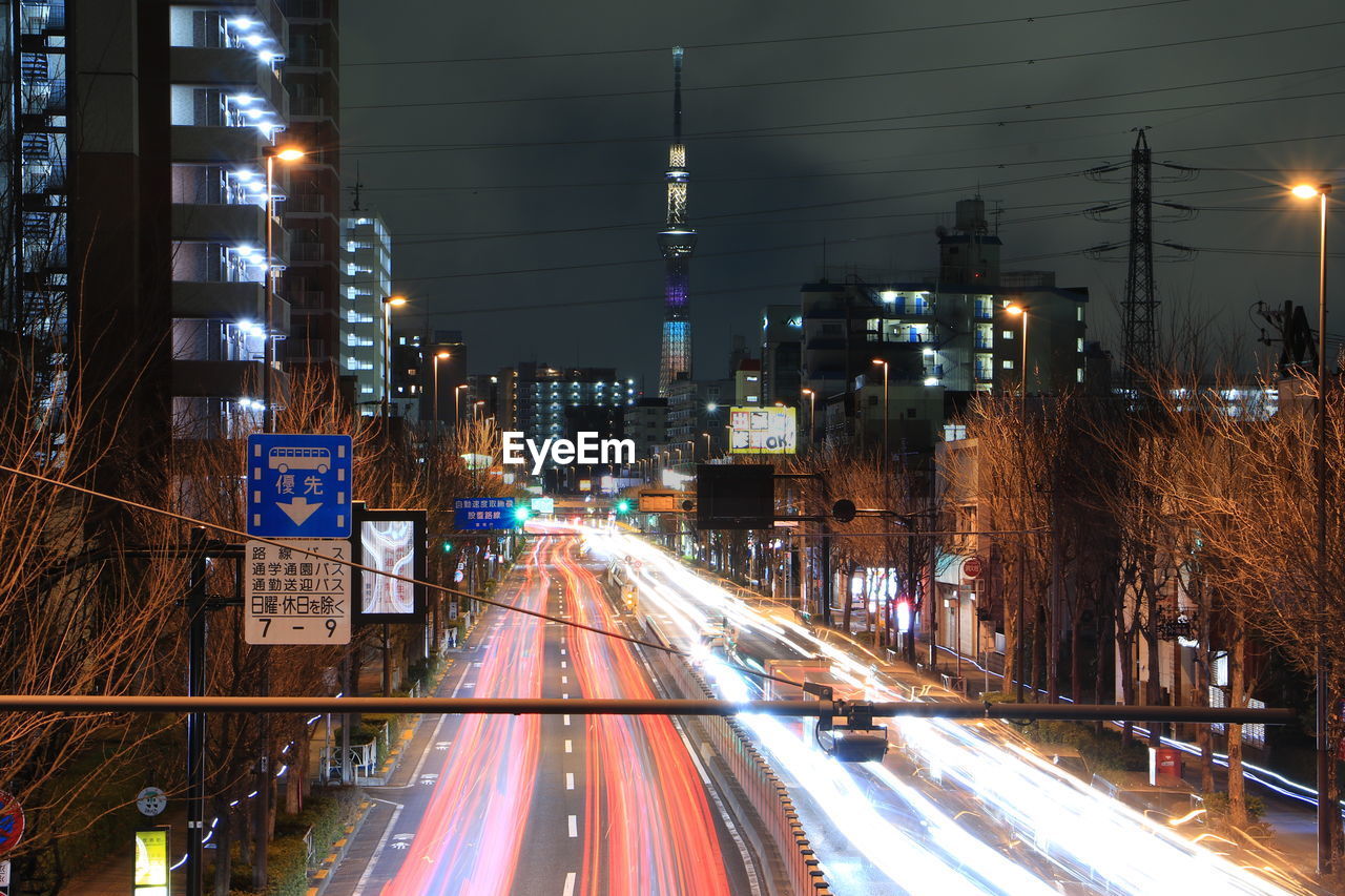 Light trails on road along buildings at night