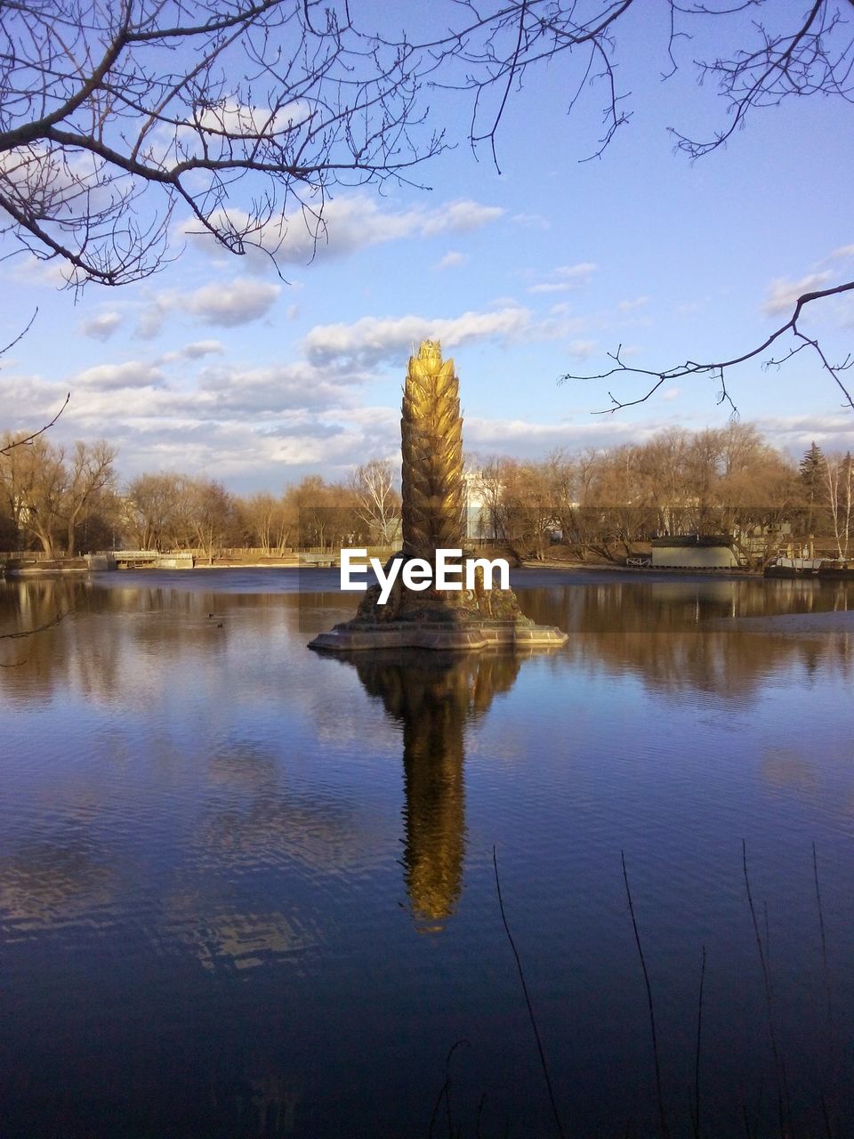 REFLECTION OF TREE IN LAKE AGAINST SKY