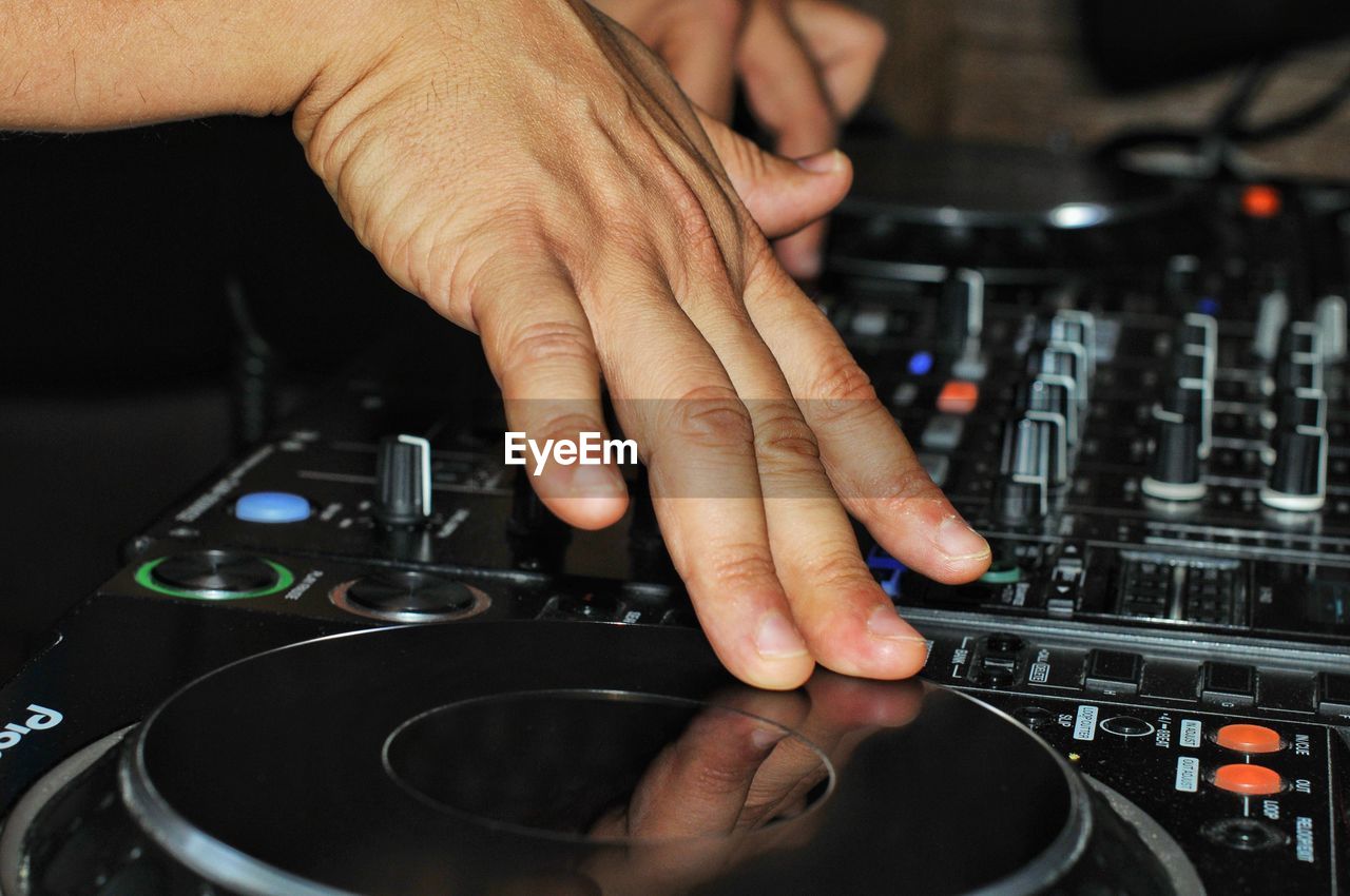 Cropped hands of dj using sound mixer