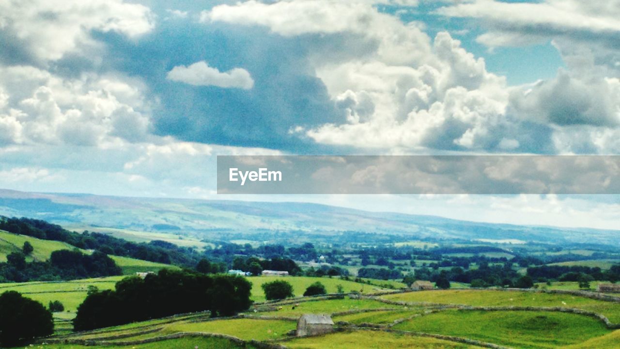 SCENIC VIEW OF MOUNTAINS AGAINST CLOUDY SKY