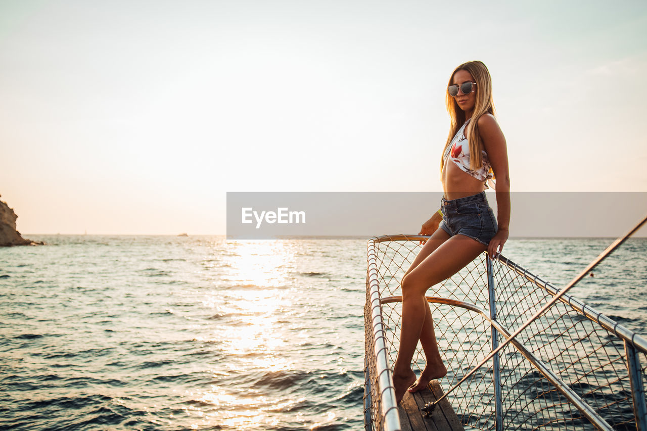 Portrait of young woman against sea and sky