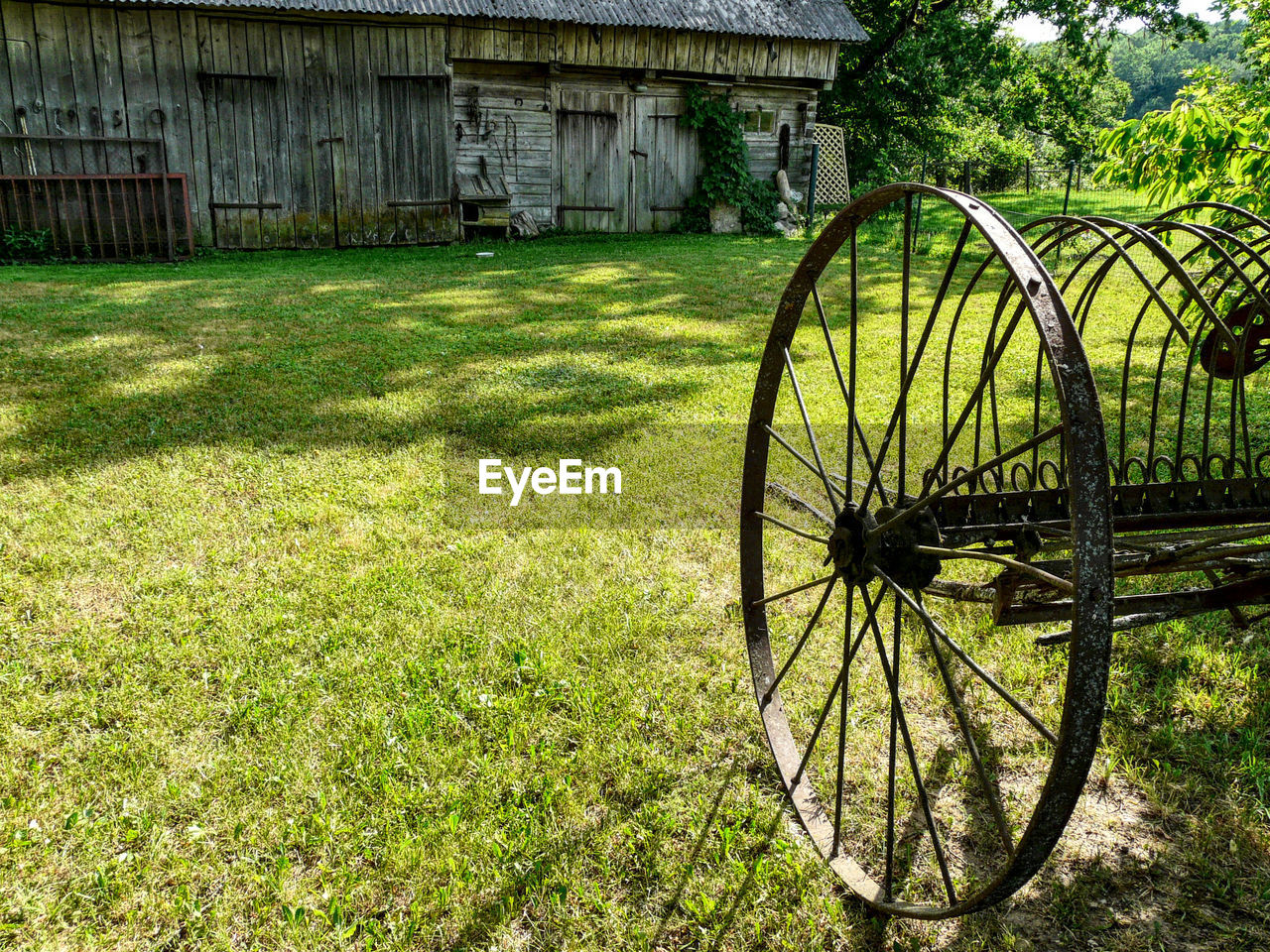 BICYCLE PARKED ON FIELD AGAINST BUILDING