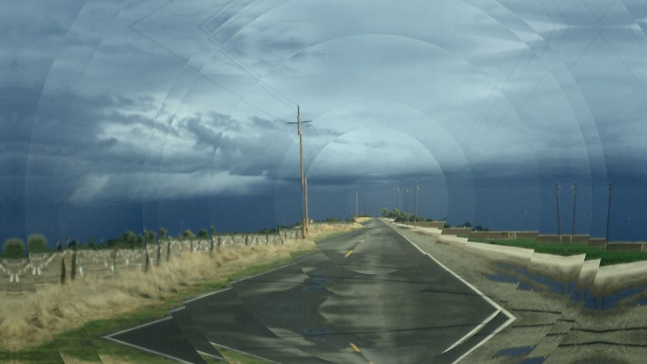 ROAD BY FIELD AGAINST SKY