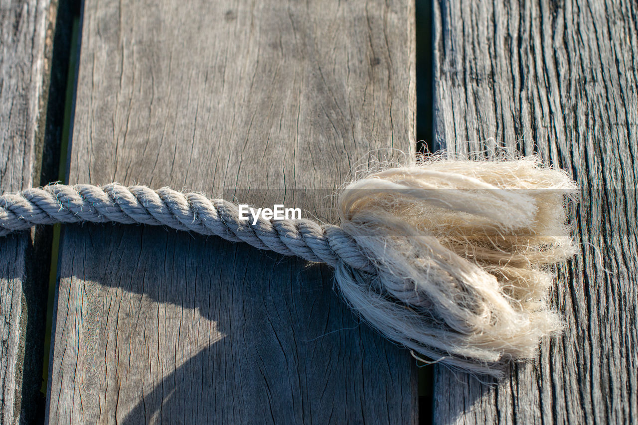 Close-up of rope on wooden plank