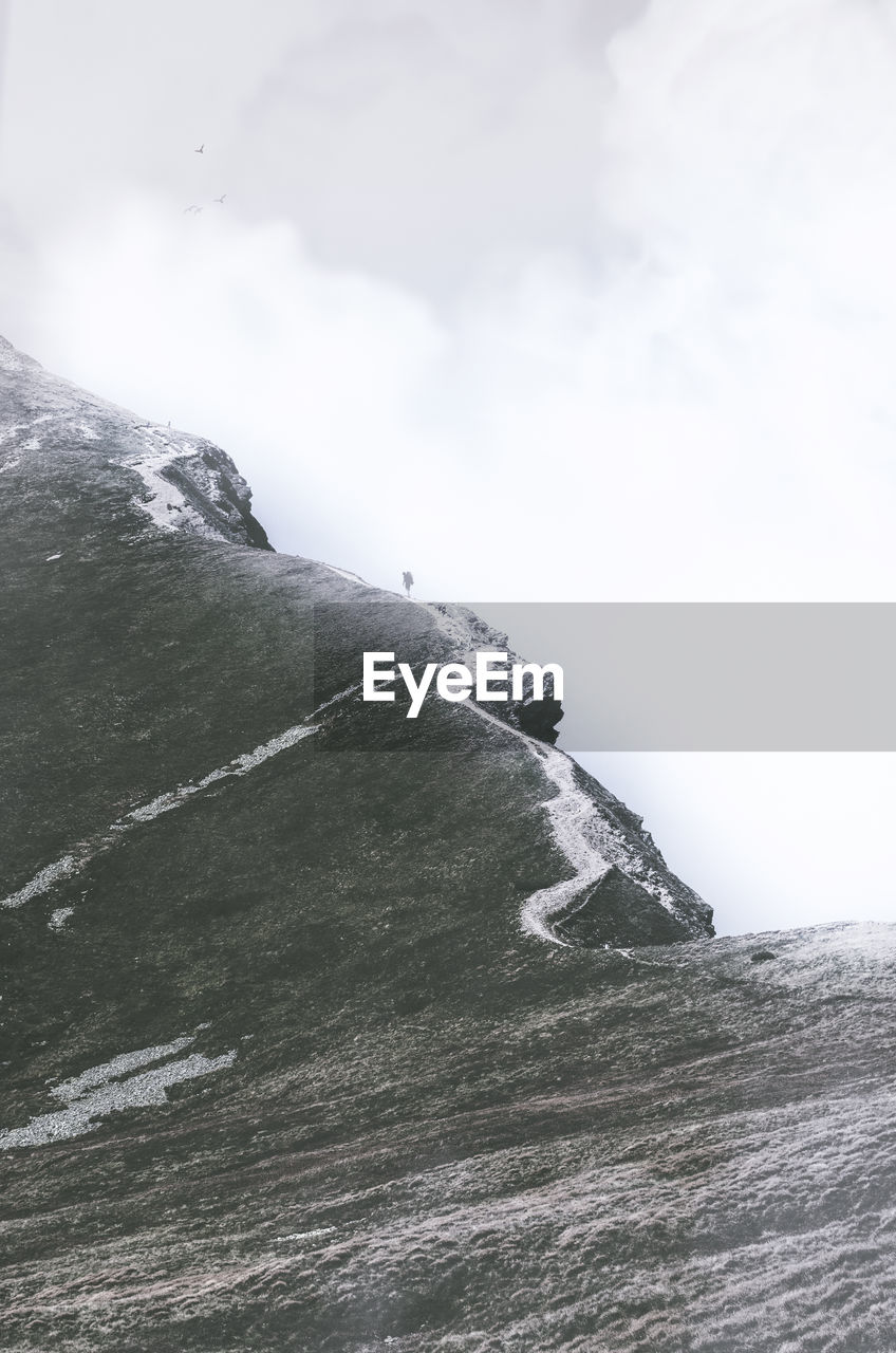 Scenic view of mountain against cloudy sky