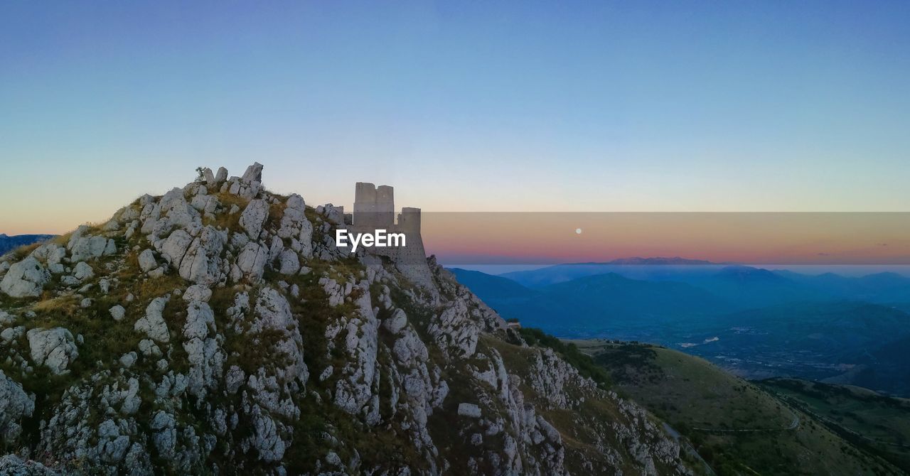 Rocca calascio on mountain at sunset