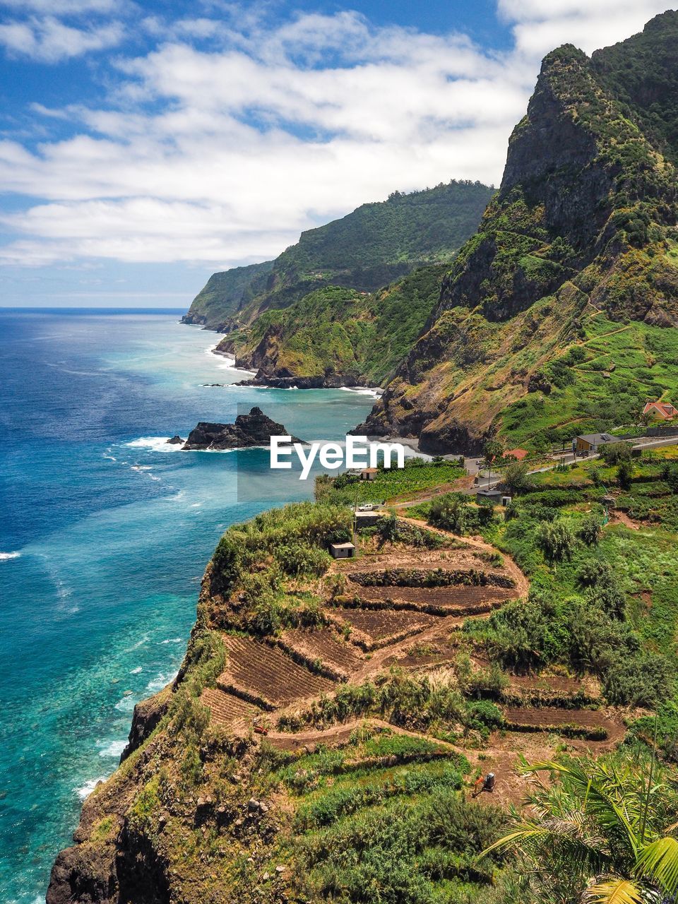 Scenic view of sea by cliff against sky