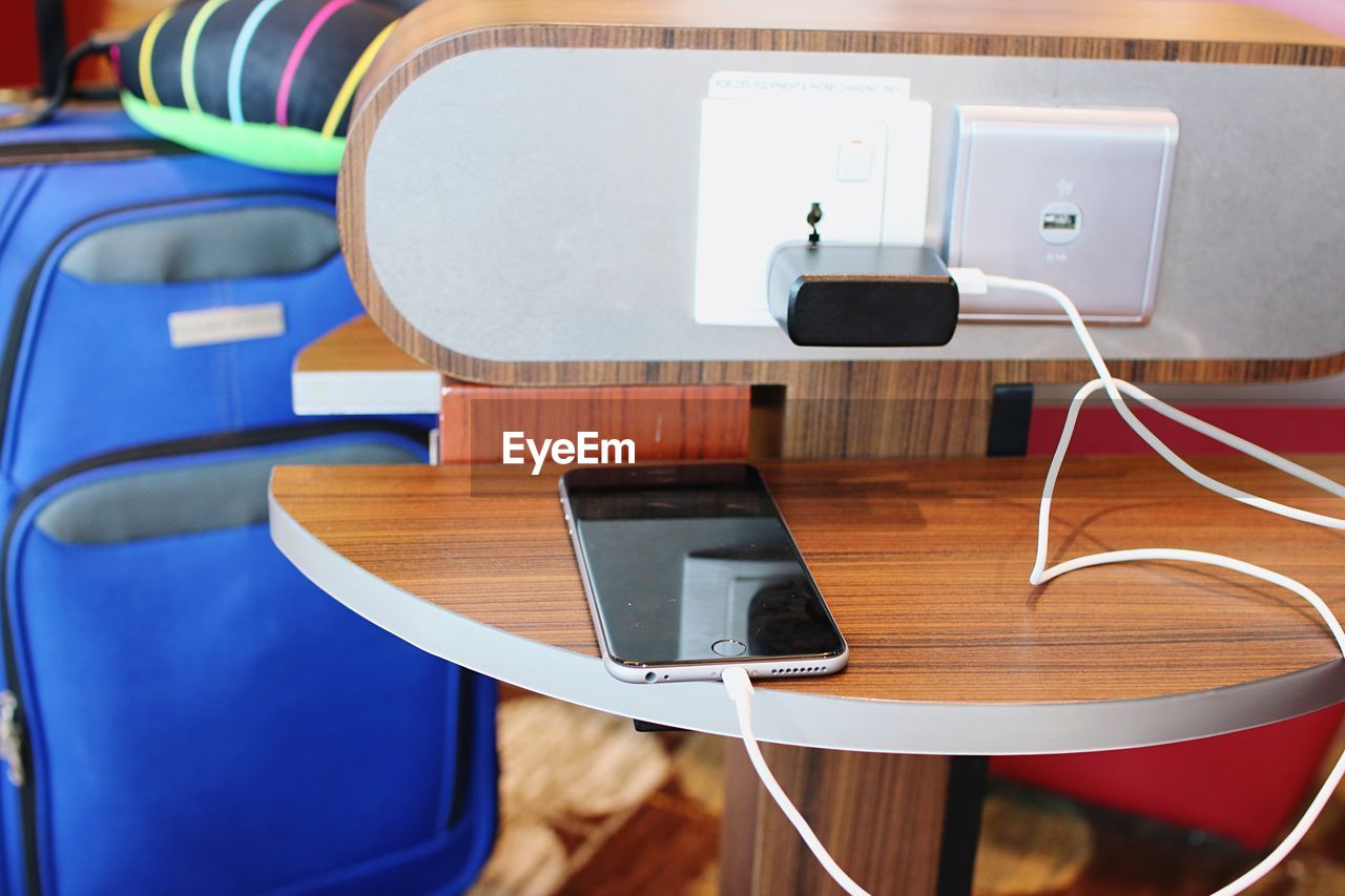 High angle view of mobile phone charging on table