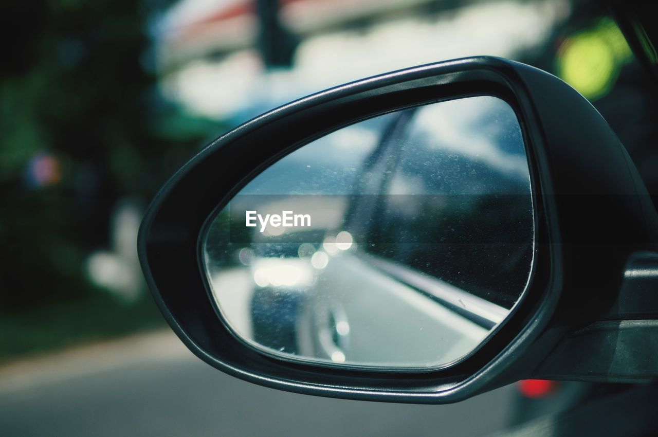 REFLECTION OF CAR ON SIDE-VIEW MIRROR OF BUS