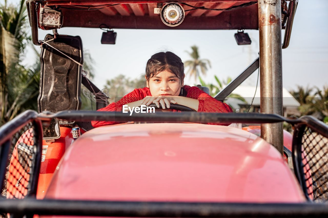 Portrait of happiness pretty beautiful chubby girl with red dress posing with vintage car.