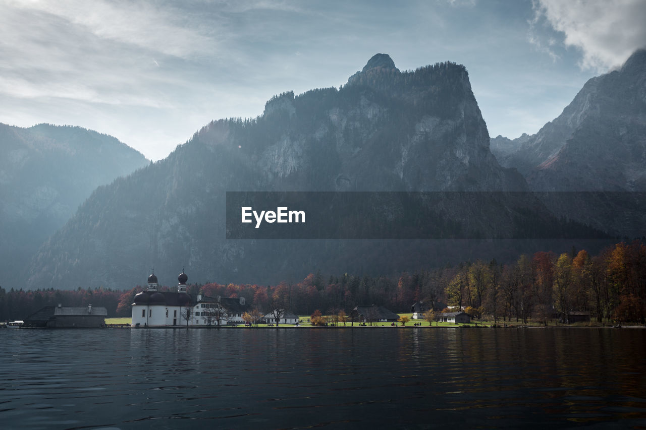 Scenic view of lake by mountains against sky