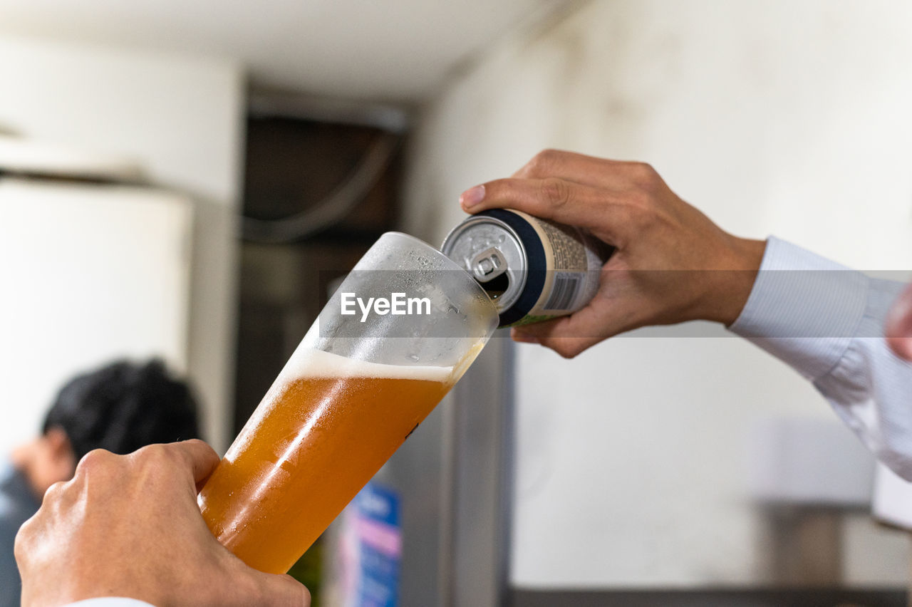 MIDSECTION OF MAN DRINKING GLASS WITH BEER