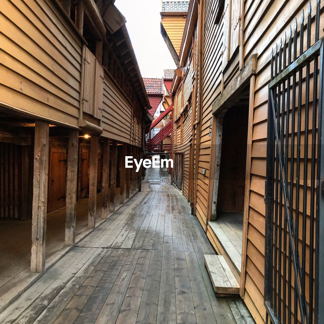 Empty wet alley amidst buildings in city