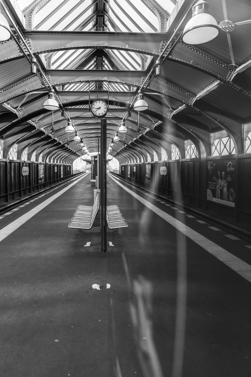 black and white, transportation, monochrome, monochrome photography, public transportation, architecture, rail transportation, indoors, railroad station, ceiling, travel, transport, mode of transportation, black, infrastructure, built structure, railroad station platform, subway, diminishing perspective, no people, lighting equipment, the way forward, public transport, line, white, train, track, metro station, railroad track, train station, illuminated, city, day, subway train