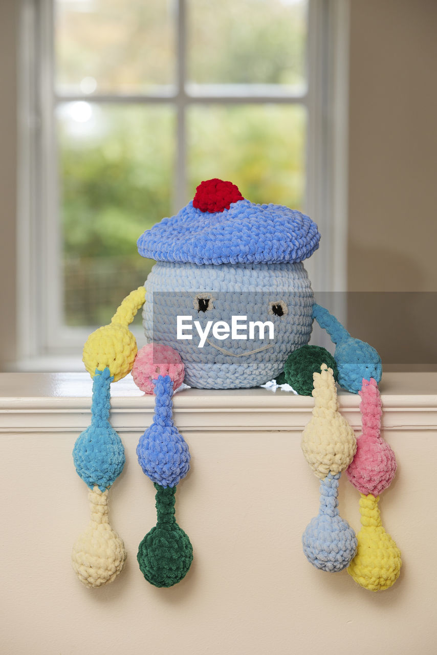 crochet, toy, indoors, window, stuffed toy, wool, representation, no people, teddy bear, textile, blue, craft, creativity, animal representation, art, home interior, still life, knitted, day, baby toys, ball of wool, animal, human representation, multi colored